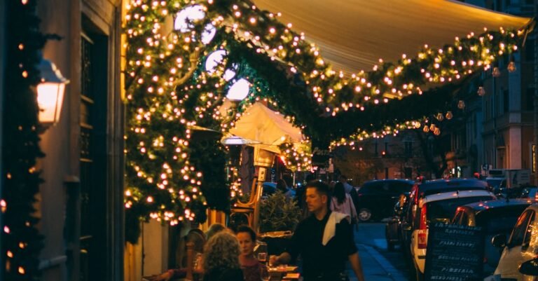 Inviting street view of a Trattoria Pizzeria with twinkling lights on a lively night.