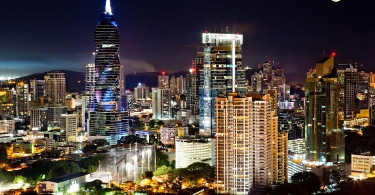 Illuminated skyscrapers under a moonlit sky in Panama City's vibrant urban landscape.